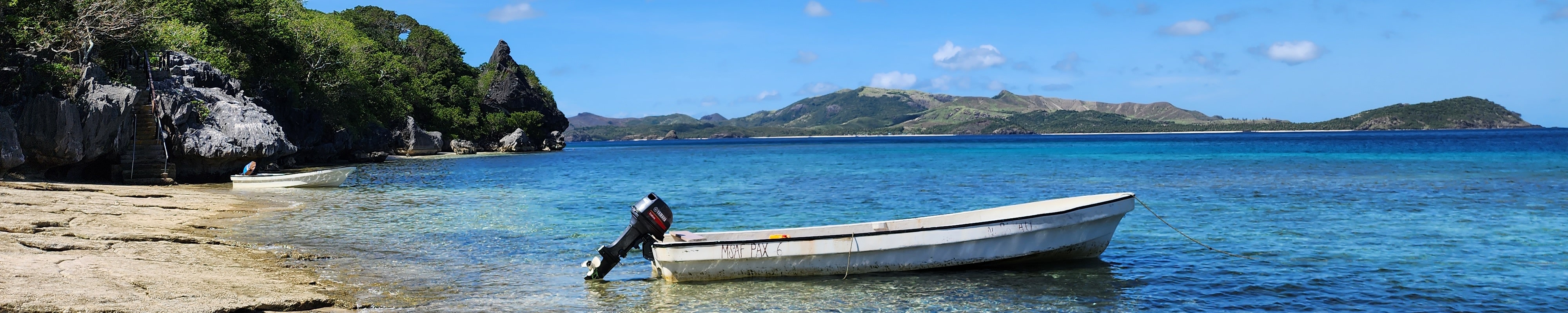 Image of small boat anchored off a beach